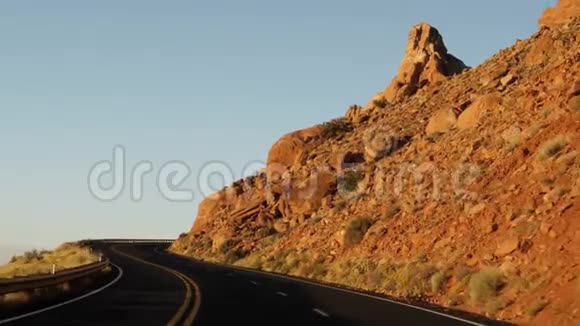 日落时分在岩石间蜿蜒的公路上行驶视频的预览图