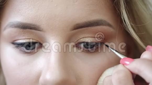 化妆师在沙龙用眼线画客户眼睛视频的预览图