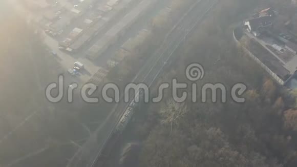 在大雾天气下在铁路轨道上训练机车在雾蒙蒙的早晨经过空中镜头视频的预览图