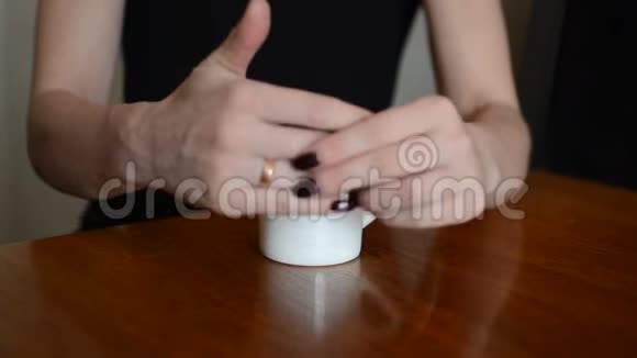 在一家咖啡屋里女人拿着一杯咖啡从手指上摘下一枚结婚戒指然后离开视频的预览图