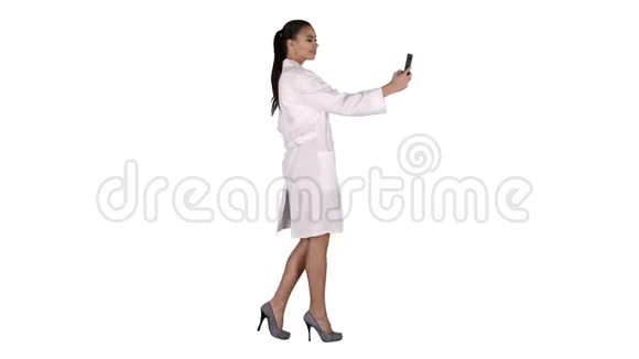 时尚的欧洲医生黑发在电话自拍而走在白色背景视频的预览图