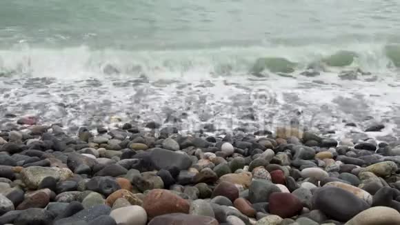 在暴风雨来临的时候海浪在鹅卵石岸上翻滚视频的预览图