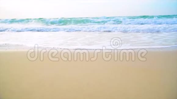 热带海滩阳光明媚的一天夏天有白色的沙子和蓝色的大海海边的宁静风光沙滩上的泡沫视频的预览图
