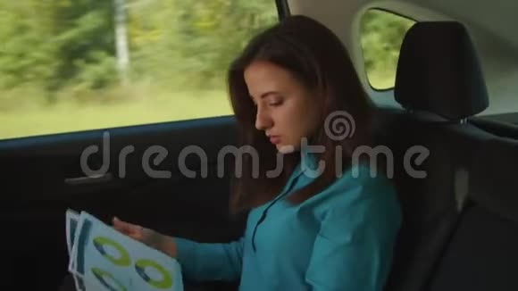 自信的女商人在车里分析文件视频的预览图