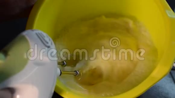 电动搅拌器将面团搅拌在盘子里视频的预览图