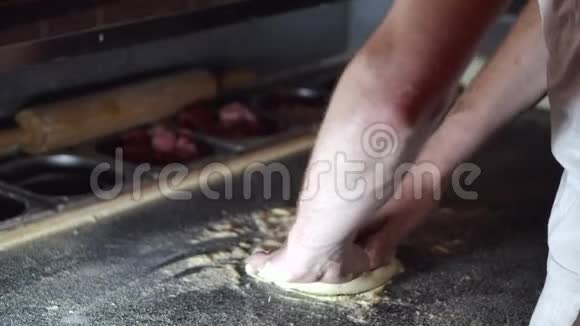 厨师在餐厅用手揉比萨饼面团视频的预览图