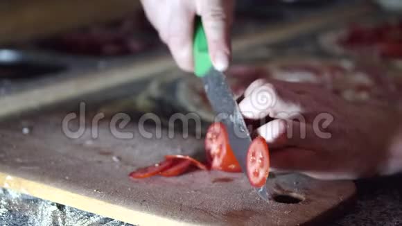 在厨房切西红柿的男性双手弯曲的视角视频的预览图