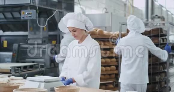 迷人的微笑美丽的面包师在面包店厨房行业的肖像直视相机享受视频的预览图