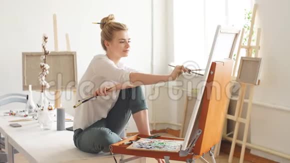 才华横溢的艺术家坐在桌子上在家画她的画视频的预览图