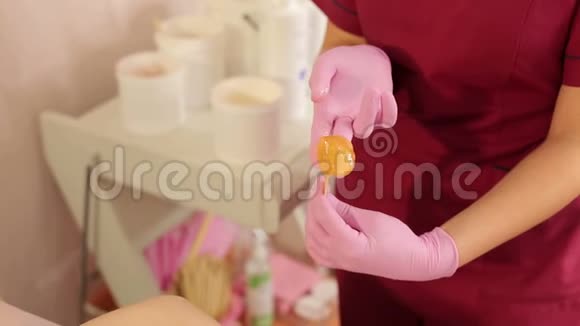 美容师从银行取出糖膏来脱毛妇女的腋窝视频的预览图