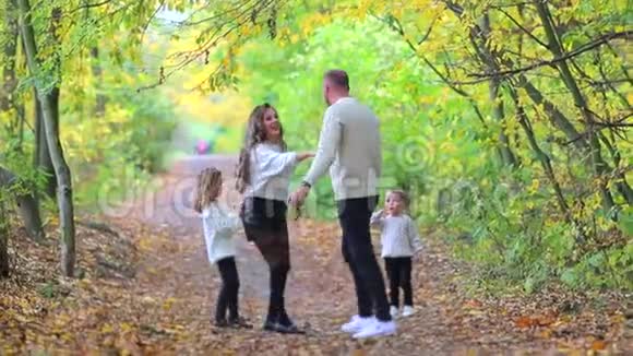 一个友好的家庭走过秋天的森林视频的预览图