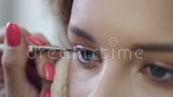 化妆师在沙龙用眼线画客户眼睛视频的预览图