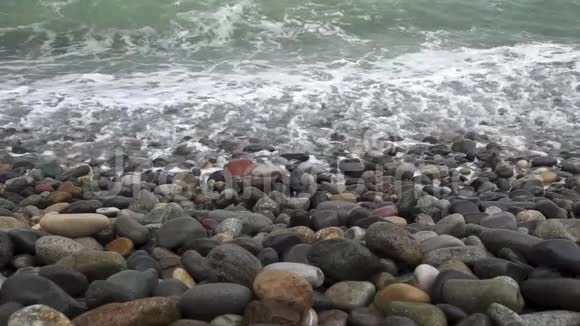 在轻风暴中海浪在鹅卵石岸上翻滚慢动作慢动作视频的预览图