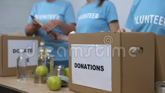 女性活动家准备供给箱把食物放在纸板箱里视频的预览图