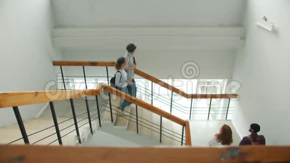 在大学里多种族的学生在楼梯上聚会做高五视频的预览图