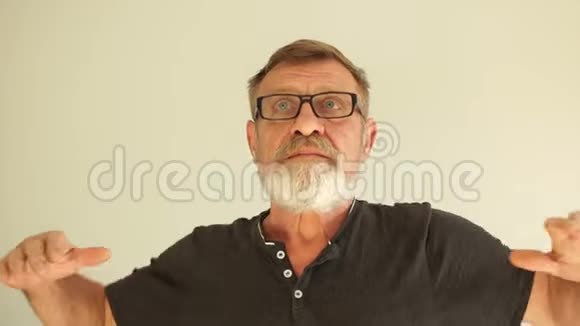 年长的灰发男子穿着黑色T恤站在白色背景上向后伸展疲惫而放松困倦视频的预览图