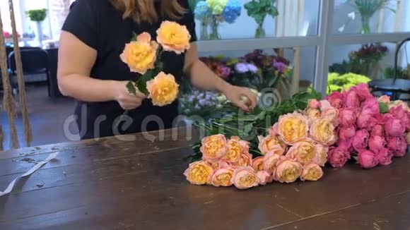 花店里的花女在做一束粉红色牡丹花特写镜头视频的预览图