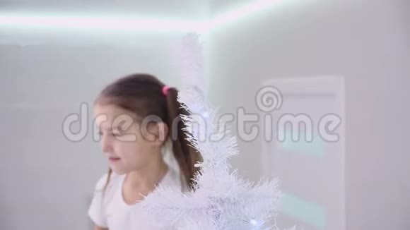 特写4k视频的一个快乐的宝宝放在背景上把天使装饰挂在圣诞树上视频的预览图