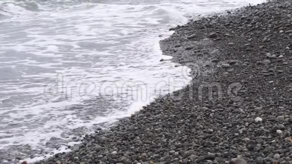 在轻风暴慢运动中海浪在鹅卵石岸上翻滚视频的预览图