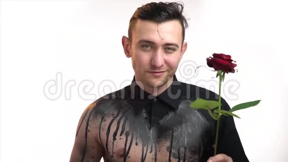 一个可爱的男人微笑着闻一朵玫瑰视频的预览图