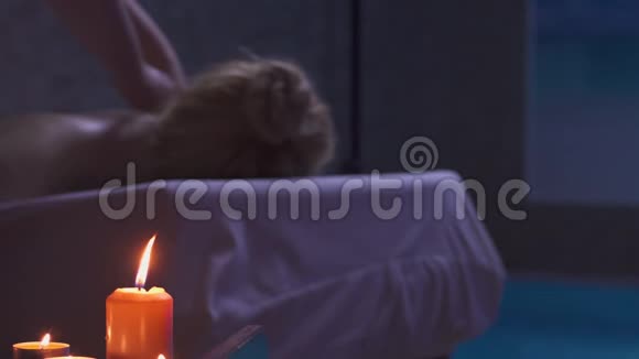 主按摩师用烛光在黑暗中按摩白种人女人视频的预览图