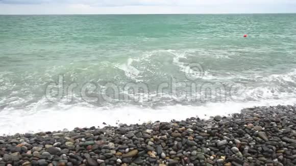 在轻风暴慢运动中海浪在鹅卵石岸上翻滚视频的预览图