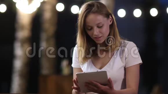 年轻女子举着数码平板电脑收到好消息感到惊讶购物者得到大折扣庆祝视频的预览图