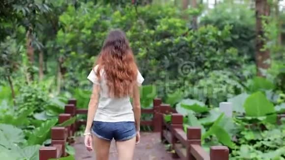 一个年轻的欧洲女孩走在木桥上视频的预览图