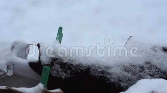冬天用绳子在街上洗洗的衣服上面覆盖着雪视频的预览图