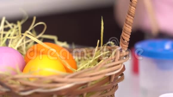 复活节快乐小女孩画复活节彩蛋女孩的手把一个彩蛋放进篮子里小可爱视频的预览图