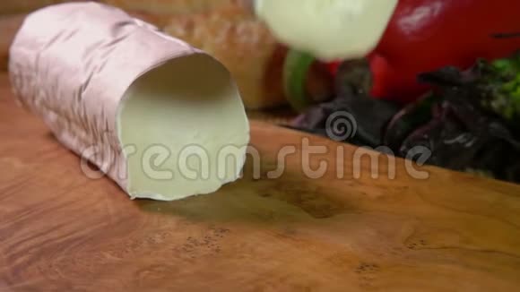 大块的山羊奶酪落在木板上视频的预览图