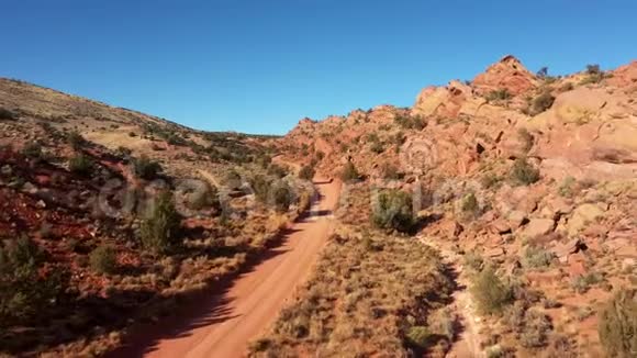 尘土飞扬的道路穿过干涸的沙漠红橙色的沙子和岩石视频的预览图