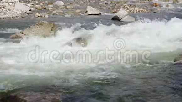阳光明媚的日子里白色的河水在岩石上流淌视频的预览图