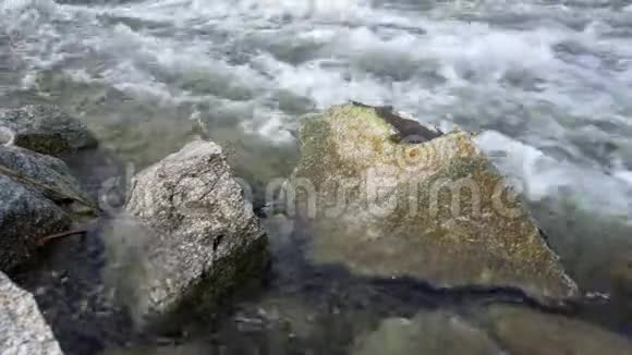 野生水流形成白浪前景巨大的尖锐岩石视频的预览图