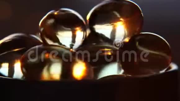 欧米茄3黄金鱼油胶囊旋转背景宏胶囊黄金油胶补充旋转运动视频的预览图