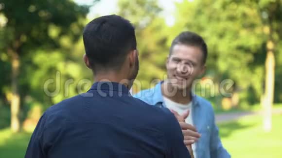 两个男性朋友突然在户外见面拥抱愉悦的情绪视频的预览图