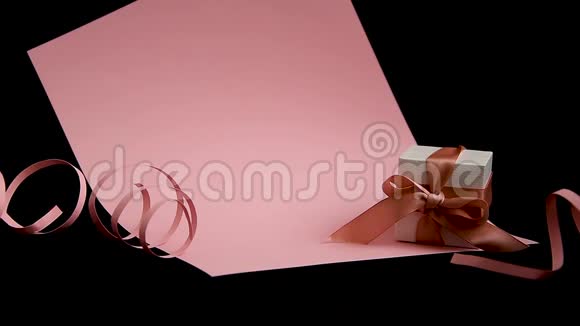 女性手在粉红和黑色背景上用粉红色丝带放置礼物盒视频的预览图