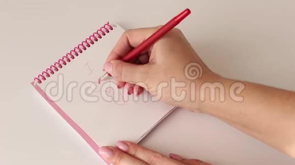女人的手在小笔记本上画一颗红心视频的预览图