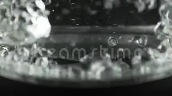 在有透明玻璃墙的水壶里水沸腾了不锈钢底部宏观镜头视频的预览图
