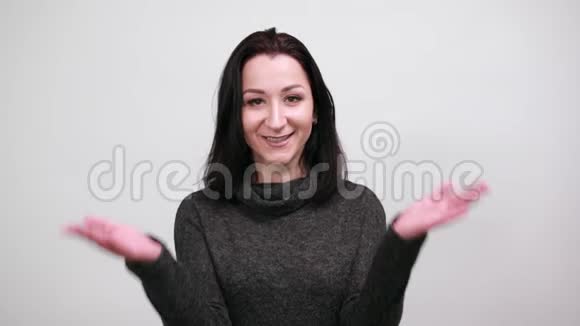 时尚黑色毛衣的开朗女人张开双手微笑着看上去快乐视频的预览图