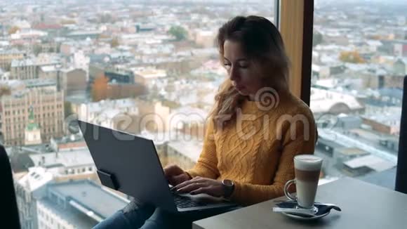 有城市视野的窗台和一位在电脑上工作的女士视频的预览图