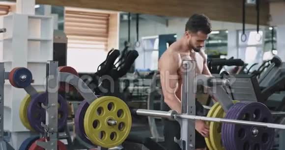 一个英俊的运动员正在举重他的胸部和身体都有纹身视频的预览图