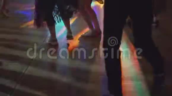 拉丁萨尔萨派对上跳舞的人们腿的剪影有多种颜色的彩虹灯跳舞的腿视频的预览图