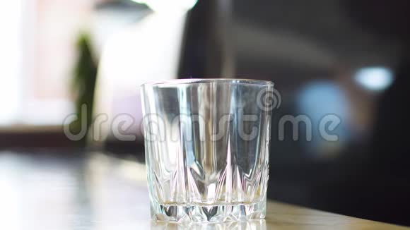 酒保把冰块倒入杯子里用来做一杯含酒精的鸡尾酒视频的预览图