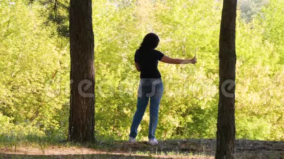 一个女孩在美丽的森林上的剪影一个女人在平板电脑上自拍视频的预览图