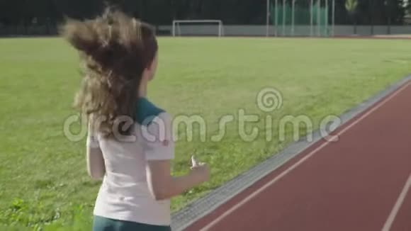 运动的年轻女孩在体育场跑步慢动作视频的预览图