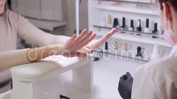 在美容院师傅让客户准备指甲进行凝胶抛光视频的预览图