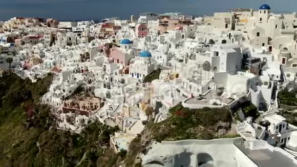 在希腊圣托里尼岛蓝色圆顶教堂上方飞行视频的预览图