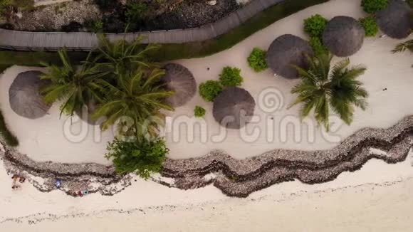 在美丽的白沙海海岸豪华海景度假胜地海滩伞的茅草屋顶的鸟瞰视频的预览图
