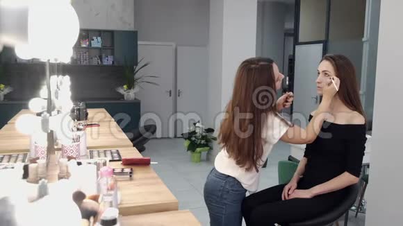 化妆师在沙龙为黑发客户化妆视频的预览图